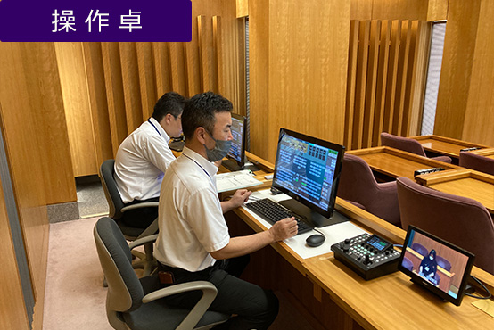 「議会運営支援システムNEO」の採用により議場内の機器操作を一括管理。発言時間の管理とマイクON/OFF管理は操作席のタッチパネルモニターを2台構成し、2名が役割分担する運営方法を採っている